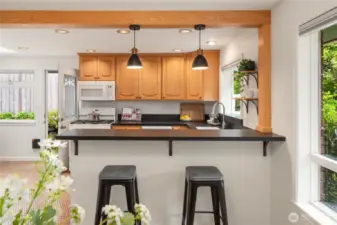 A breakfast bar with pendant lighting and Paperstone counters.