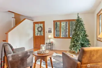 Cozy-up and refresh and relax in the Living room area of the homes main level. Cherry-wood floors. Wood trimmed windows.