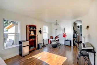 Currently set up as a music room, this is a living space upon entry.