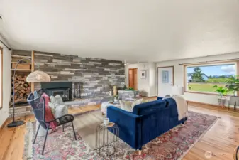 Gorgeous rock wall flanks great room - features newer wood burning insert and wood storage as well as a built in planter...