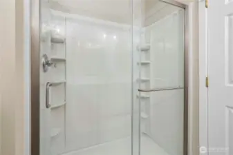 Spacious walk-in shower with built-in storage for convenience