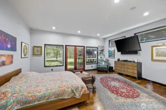 Nestled within the heart of this beautifully designed home, the main floor primary bedroom with ensuite epitomizes the very essence of modern luxury and comfort.  Complete with fireplace, this sanctuary is thoughtfully curated to provide retreat from the hustle and bustle of daily life.  French doors lead you to private patio overlooking lush acreage.