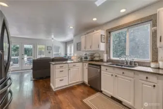 This angle shows the casual space off of the beyond user friendly kitchen that has been recently updated.  Lots of cabinetry and the granite counters are gorgeous.  The French doors in the back of the photo lead to the awesome deck for outside enjoyment.