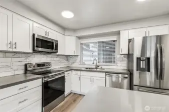 The updated kitchen boasts quartz counters and stainless steel appliances.