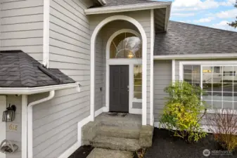 A covered, arched entry with a dramatic transom window adds character while keeping arrivals protected from the elements. The recessed front door creates a nice sense of privacy and a warm welcome for guests.