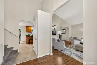 Step into a bright foyer that opens to vaulted living space and easy sight lines toward the kitchen and dining area. This level also includes a convenient powder room, ideal for guests and everyday use.