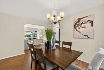A classic chandelier and wide proportions make this dining room a true gathering space for dinners, game nights, or holiday meals. The open passage to the living room keeps everyone connected while still feeling nicely defined.