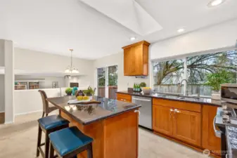 The kitchen offers abundant counter space, a center island for prep and serving, and a bright skylight that keeps the space feeling light throughout the day. A large window over the sink and quick access to the outdoor deck make indoor, outdoor meals and entertaining feel easy.