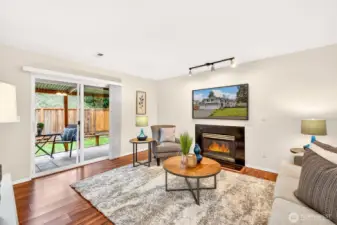 Downstairs, a comfortable bonus living area offers flexible space for movie nights, hobbies, or a home office setup. The fireplace adds warmth and ambiance, and the sliding door creates a natural connection to the covered patio and backyard.