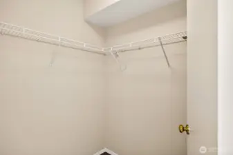 A walk in closet provides valuable storage with wraparound shelving for wardrobes, shoes, and seasonal items. It’s a simple feature that makes the primary suite feel complete and organized.