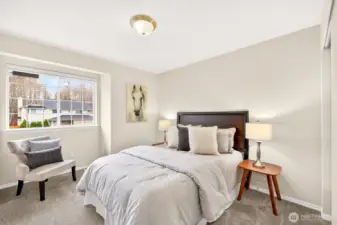 A secondary bedroom offers comfortable proportions and soft carpet underfoot, with natural light from the window. It works well as a guest room, home office, or dedicated hobby space.