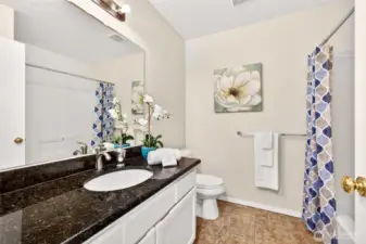 The full hall bath is clean and functional with a tub and shower combination and a substantial vanity counter. An oversized mirror and strong lighting keep the space bright for daily use.