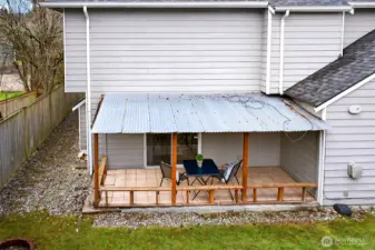 This exterior view highlights the covered patio and the easy access from the home to the backyard. It’s a practical setup for outdoor dining, lounging, or weekend projects, with fencing that adds privacy and definition to the space.