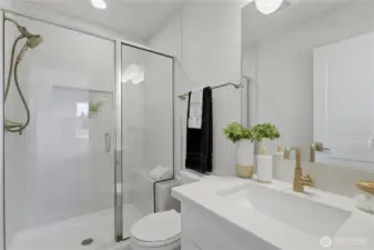 Primary bath with quartz countertops and modern fixtures