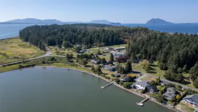 The road leading on to Samish Island. Skagit Land Trust property on the west side of the road. 11586 Scott Rd. is the white building between homes with docks.