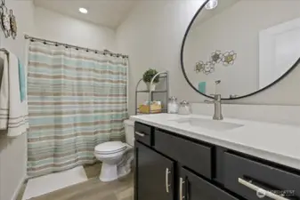 Main Floor Full bath is adjacent to Guest Bedroom and has been updated in 2022 with new LVP flooring, Quartz Countertop, undermount sink and faucet, vanity hardware and lighting