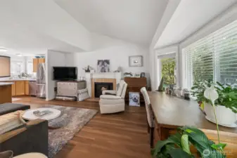 Spacious living room with vaulted ceilings, perfect for relaxing or entertaining. Enjoy the charm of brand-new luxury vinyl plank flooring and the efficiency of new vinyl windows that bring in tons of natural light.