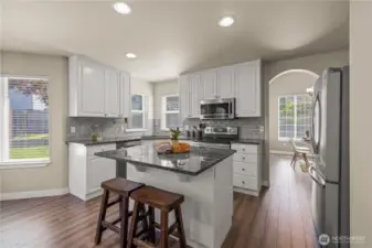 Large open kitchen with updated, stainless appliances, and island flowing to the family room and backyard patio.