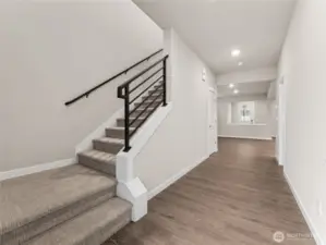 One of the main entry area with wide hallway and open metal railings.  Actual home is under construction and materials, colors, and finishes will vary. See site agent for details Actual home is under construction and materials, colors, and finishes will vary. See site agent for details. Actual home is under construction and materials, colors, and finishes will vary. See site agent for details.