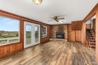 A comfortable lower-level family room offering flexible living space, highlighted by a fireplace with a newer insert. Ideal for movie nights, hobbies, or a cozy retreat on cooler days, the ceiling fan to helps circulate warmth in the winter and keeps the space cool in the summer. There is also additional under the stair storage