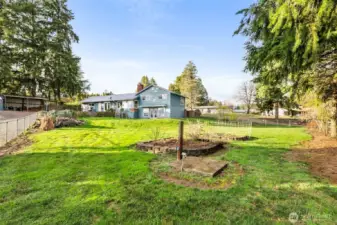 The backyard is a special space offering raised garden beds, a tranquil pond, and secure fencing—perfect for gardening and unwinding outdoors.
