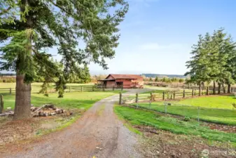 A second driveway leads directly to the barn/shop, while an additional drive provides easy access to the wood shed and RV parking.