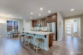 Kitchen with all SS Appliances, Quartz Countertops, Gas Stove/Oven, Beech Wood Shaker Cabinets, Large Pantry, & spacious island with bar stools.