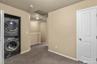 Bonus area between two bedrooms with stackable washer & dryer tucked away in a closet.