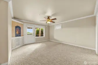 Spacious primary bedroom with door out to covered patio and cozy gas fireplace and built ins.