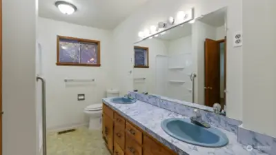 Main bath with dual sinks and walk-in shower for easy access.