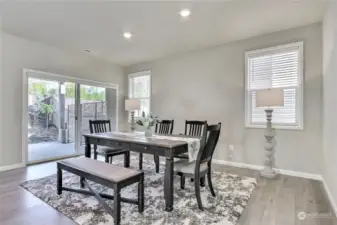 The dining room, conveniently located just off the kitchen, showcases beautiful hardwood laminate flooring that flows effortlessly through the main living areas. Sliding glass doors lead to a covered outdoor patio, transforming this space into an entertainer's dream—perfect for blending indoor elegance with outdoor relaxation!