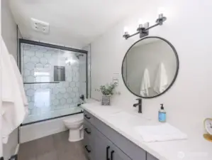 Guest bath with Black surround glass shower door..Tile Floors