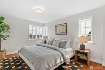 Each of the three upstairs bedrooms features its own private en-suite bath, offering ideal accommodations for guests, family, or flexible living. Designed to comfortably fit king-size beds, each light-filled room is well-proportioned and appointed with hardwood floors, classic trim details, and generous custom closet systems behind paneled doors.