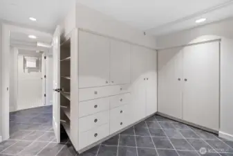 Custom cabinetry by I&B Wood, Inc. ensures ample storage throughout. Not shown is a built-in ironing board, seamlessly tucked away for added efficiency.
