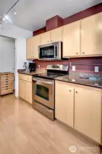 Stainless steel appliances and stone countertops. Here there is plenty of cabinet and counter space.