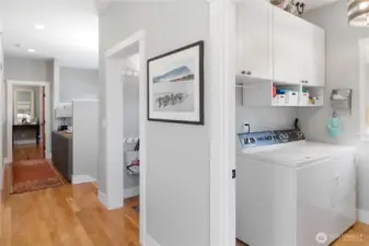 View of the laundry room looking down the hall. red oak flooring. Not shown, folding table in laundry room.