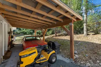 Covered carport & dog run. The side door leads into the mud room.