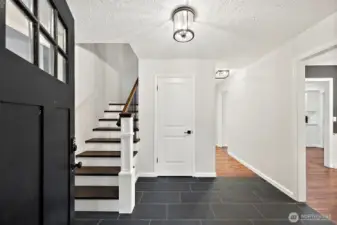 Step inside to a tiled entry way leading to dining and living rooms on either side and the staircase leading to upstairs bedrooms.