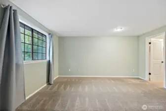Primary Bedroom with a window looking out to front yard and bringing in the morning light
