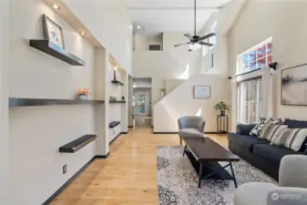 Soaring ceilings offer fan w/light and built-in shelves on left wall.  Hardwood floors throughout the main floor.    Many large windows makes this area light & bright.