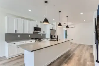 ***UNIT B Actual Kitchen - custom quartz countertops and black pendant lighting.