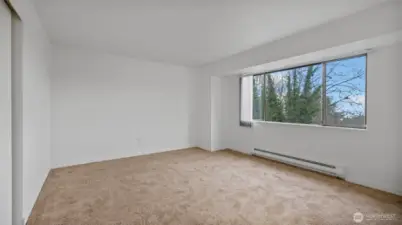 Another angle of the primary bedroom showcasing the abundance of natural light.