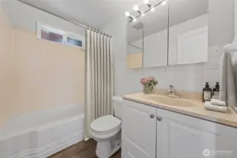 A full bathroom with a tub/shower combo, ample storage, and vanity lighting—ready to serve both family and guests. (Virtually Staged)