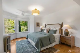 Wake up to sunlight in the grand primary suite, featuring bay windows, a private bath and spacious walk-in closet with custom storage