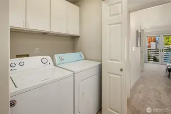 Full size washer and dryer stay with the home. Convenient cabinet storage above