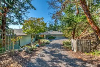 The driveway has a small fenced garden area.