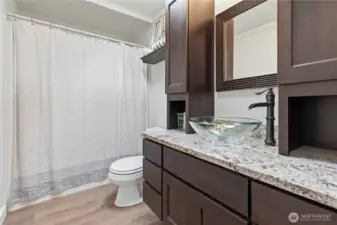 Guest bathroom is complete with tub, new flooring, new vanity and fresh paint.