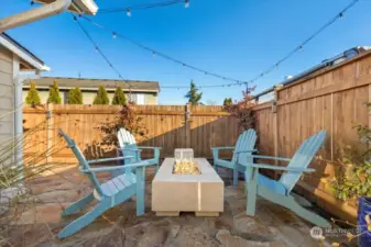 Beautiful gathering area on the flagstone patio with a gorgeous fire pit (stays with home!) and string lights, creating a relaxing and good vibes environment