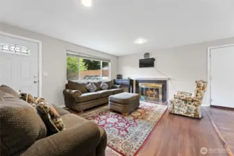 Spacious Family Room with wood fireplace, light and bright new windows, laminate wood floors and fresh paint.