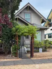 Grape arbor and ornamental cherry adorn the front entrance, with a view to the gorgeous rose garden next door!